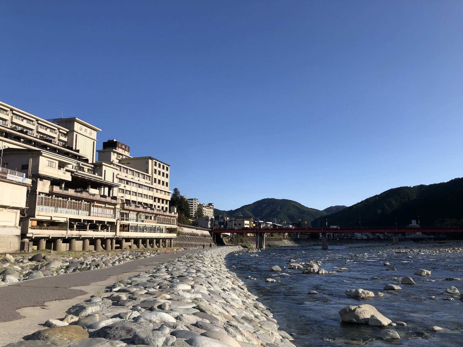 青空の下の下呂温泉の旅館街と川原