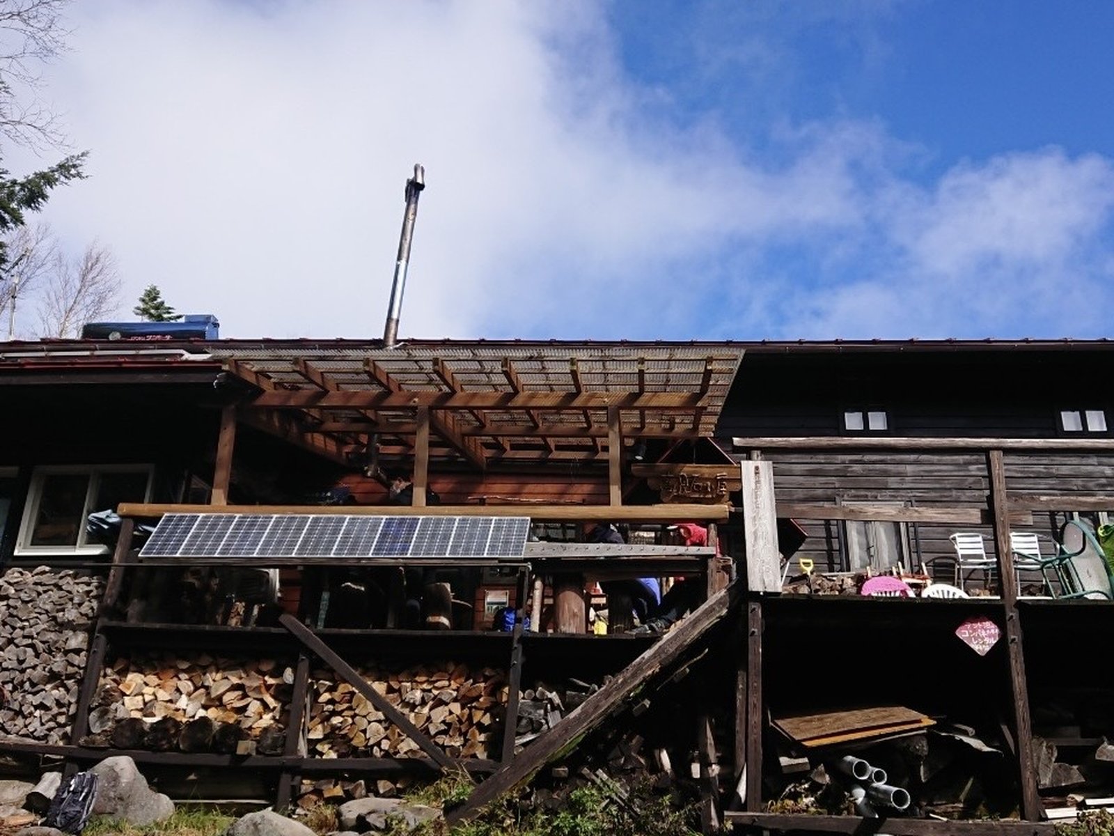 青空の下の高見石小屋 薪が積まれた北八ヶ岳の山小屋 ヤマカルテ